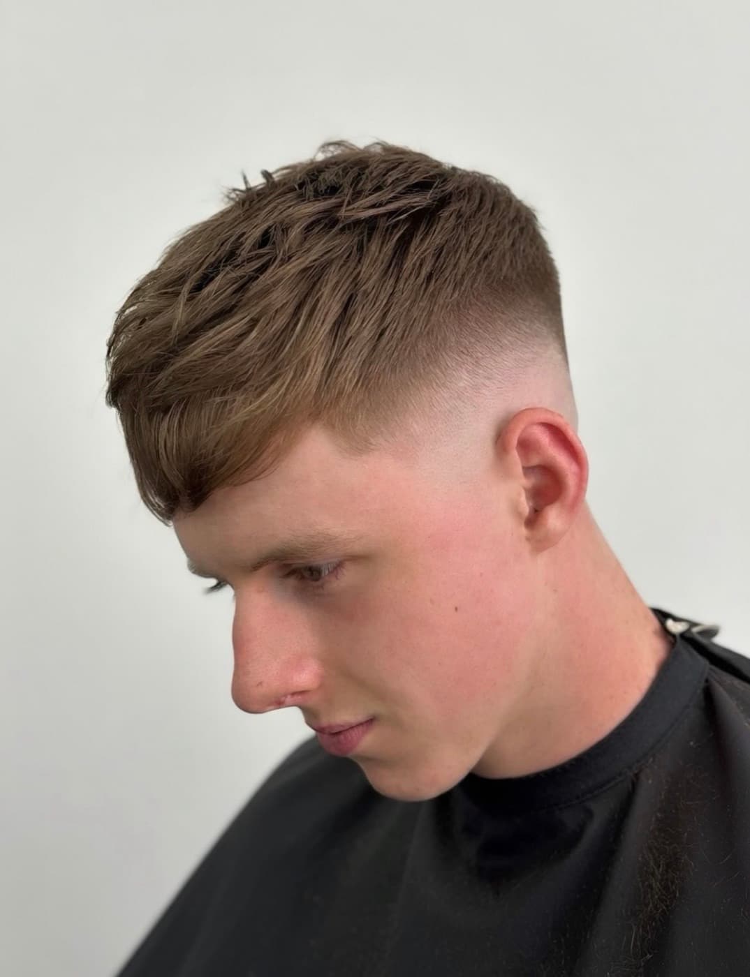 Textured crop with a forward fringe and a mid skin fade, finished at Leo's Barbers
